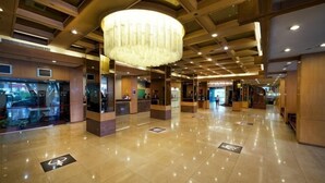 A spacious lobby with a large chandelier, a reception desk, and a clean, polished floor. - Hotel Royal Singapore (Singapore)