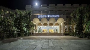 The entrance of Irene Palace with a stone pathway leading to the entrance, surrounded by greenery. - Irene Palace (Rhodes)