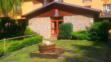 Un edificio de piedra con una puerta de madera y un letrero que indica un hospital.