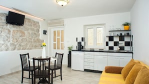Un espacio habitable compacto con comedor, kitchenette y sofá.