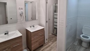 A modern bathroom with two sinks, a mirror, and a toilet. - Hostal Las Fronteras (Torrejón de Ardoz)