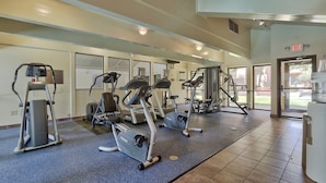 Une salle de sport équipée de tapis de course, de vélos elliptiques et de matériel de musculation.