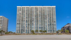 A high-rise hotel with multiple floors, balconies, and a clear view of the surrounding area.