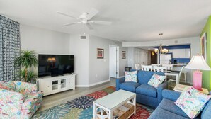 Ein Wohnzimmer mit Sofa, Fernseher und Deckenventilator.