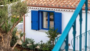 Ein weißes Gebäude mit blauen Fensterläden und einem Ziegeldach.