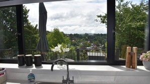 A modern kitchen with a large window overlooking a scenic landscape.