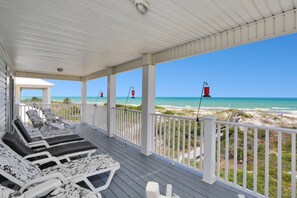 A covered deck with lounge chairs and a view of the beach. - A Tropical Breeze (Port St. Joe)