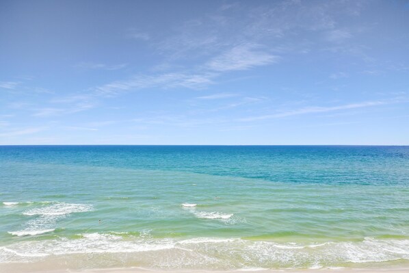A beach with clear blue water and a sandy shore.