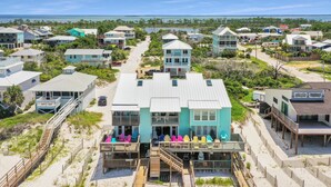 Un hôtel situé en bord de mer, composé de plusieurs bâtiments, avec une plage de sable et une vue dégagée sur l’océan.