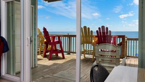 Une terrasse avec des chaises donnant sur l’océan.