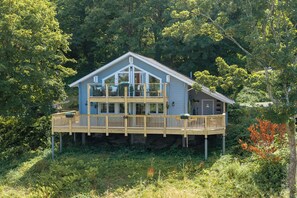 A two-story house with a balcony, surrounded by dense greenery. - The Rowan - Luxury Lodge and Woodland Views (Penally)