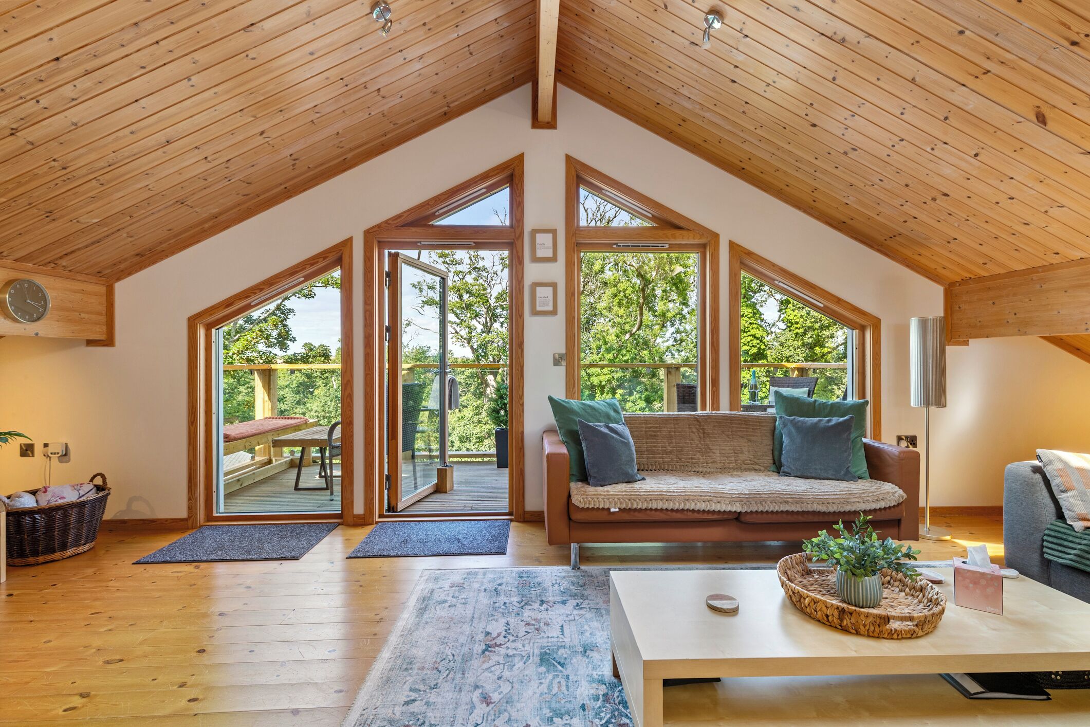 Un loft spacieux avec de hauts plafonds, de grandes fenêtres, un coin salon confortable et un plancher en bois.