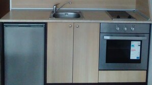 A compact kitchen with light wood cabinets, a built-in dishwasher, and a stainless steel oven. - 1 Bed - Sleeps 4 - Pets - Mountain Views (Razlog)
