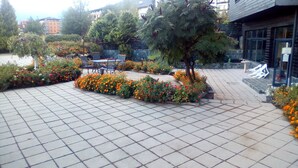 A courtyard with tiled flooring, potted plants, and outdoor seating. - 1 Bed - Sleeps 4 - Pets - Mountain Views (Razlog)