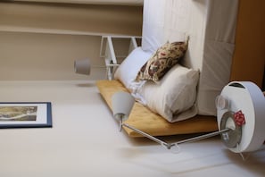 A neatly made bed with a pillow, a bedside lamp, and a white bedside table with a tissue box. - Le Pleiadi - three rooms apartment (Pescara)