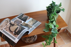 A wooden table with a magazine, a coffee grinder, and a potted plant. - Le Pleiadi - three rooms apartment (Pescara)