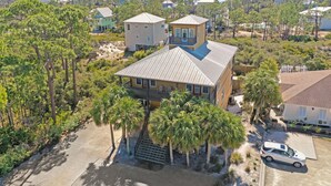 A coastal house with a balcony, surrounded by pine trees and a view of the ocean. - Big Chill (Port St. Joe)