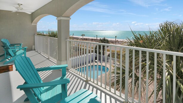 A balcony with turquoise chairs, a pool, and a view of the beach and ocean. - Beach Destiny (Port St. Joe)