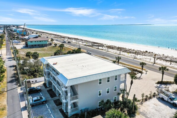 A multi-story building with a flat roof, located near a beach with a clear blue sky. - Beach Destiny (Port St. Joe)