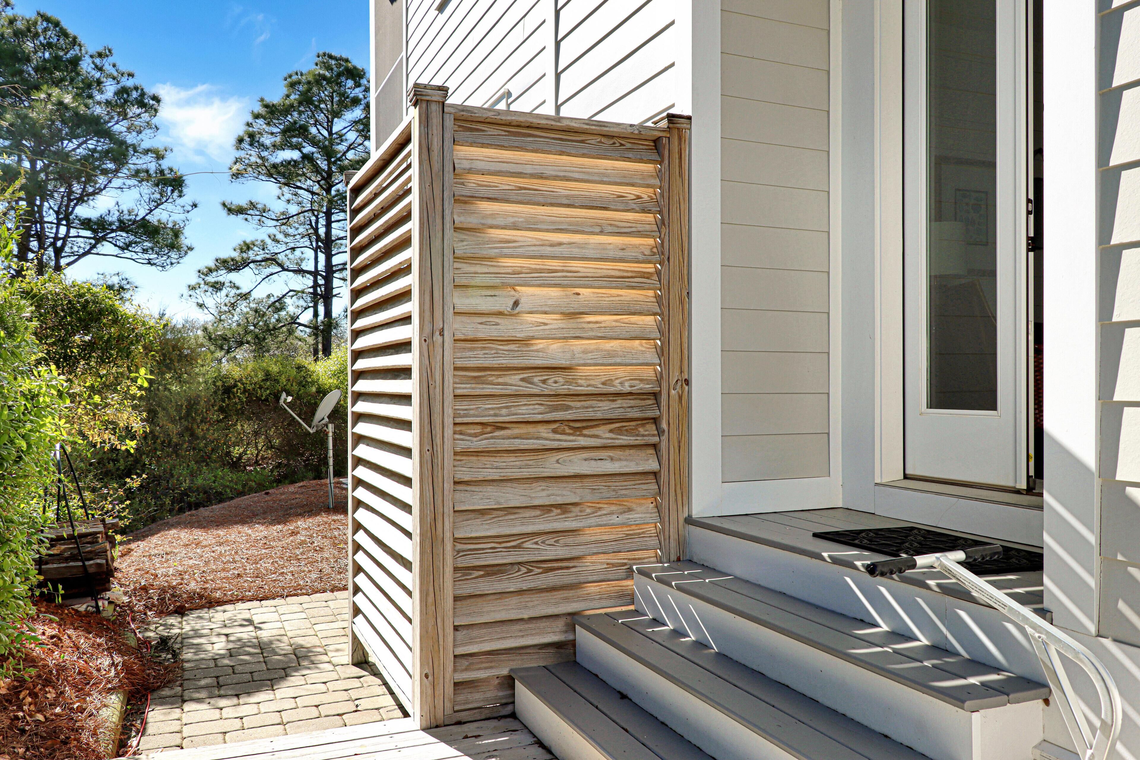 Une clôture en bois, un escalier menant à une porte et un ciel dégagé.