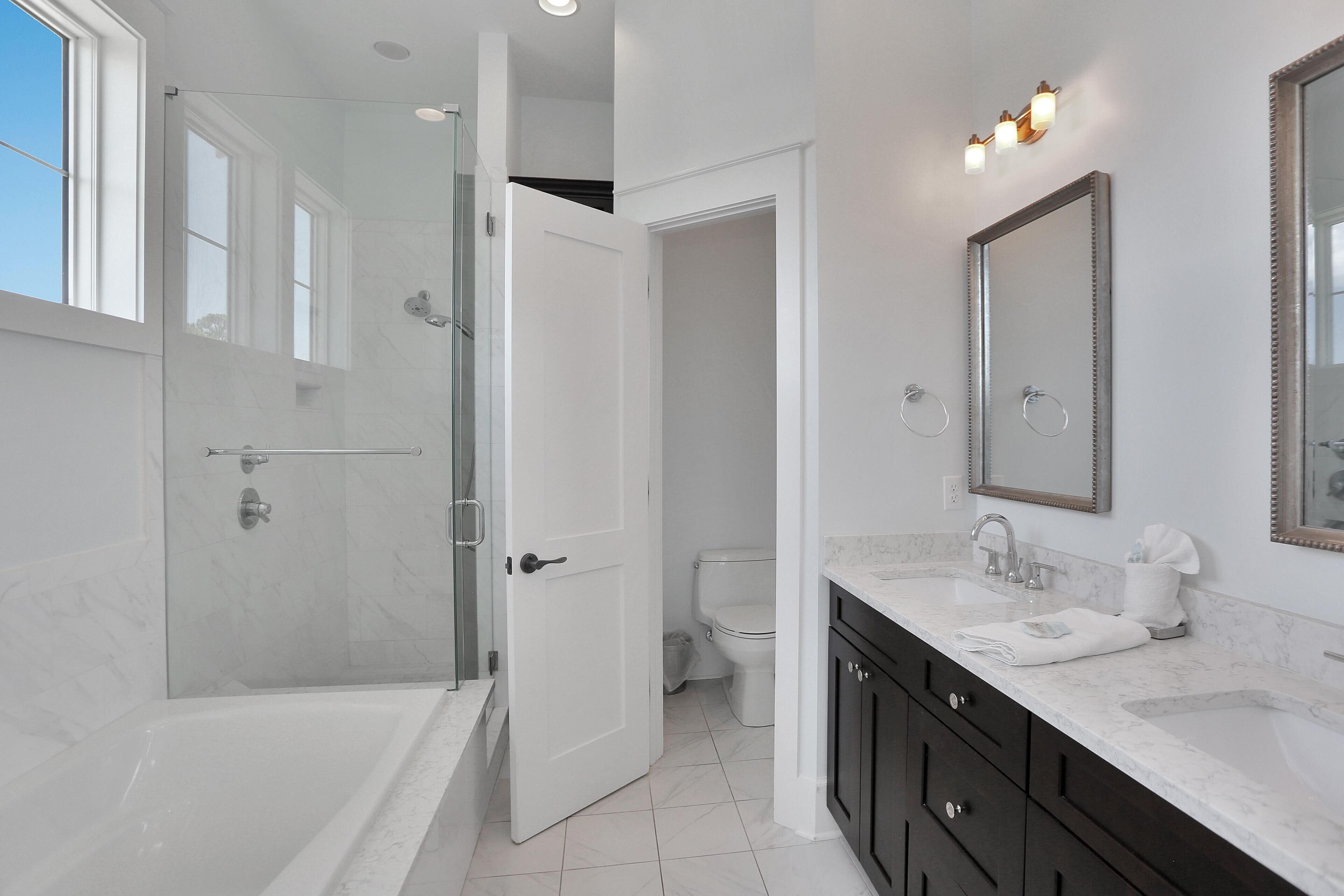 A modern bathroom with a bathtub, a shower, a toilet, and a sink.