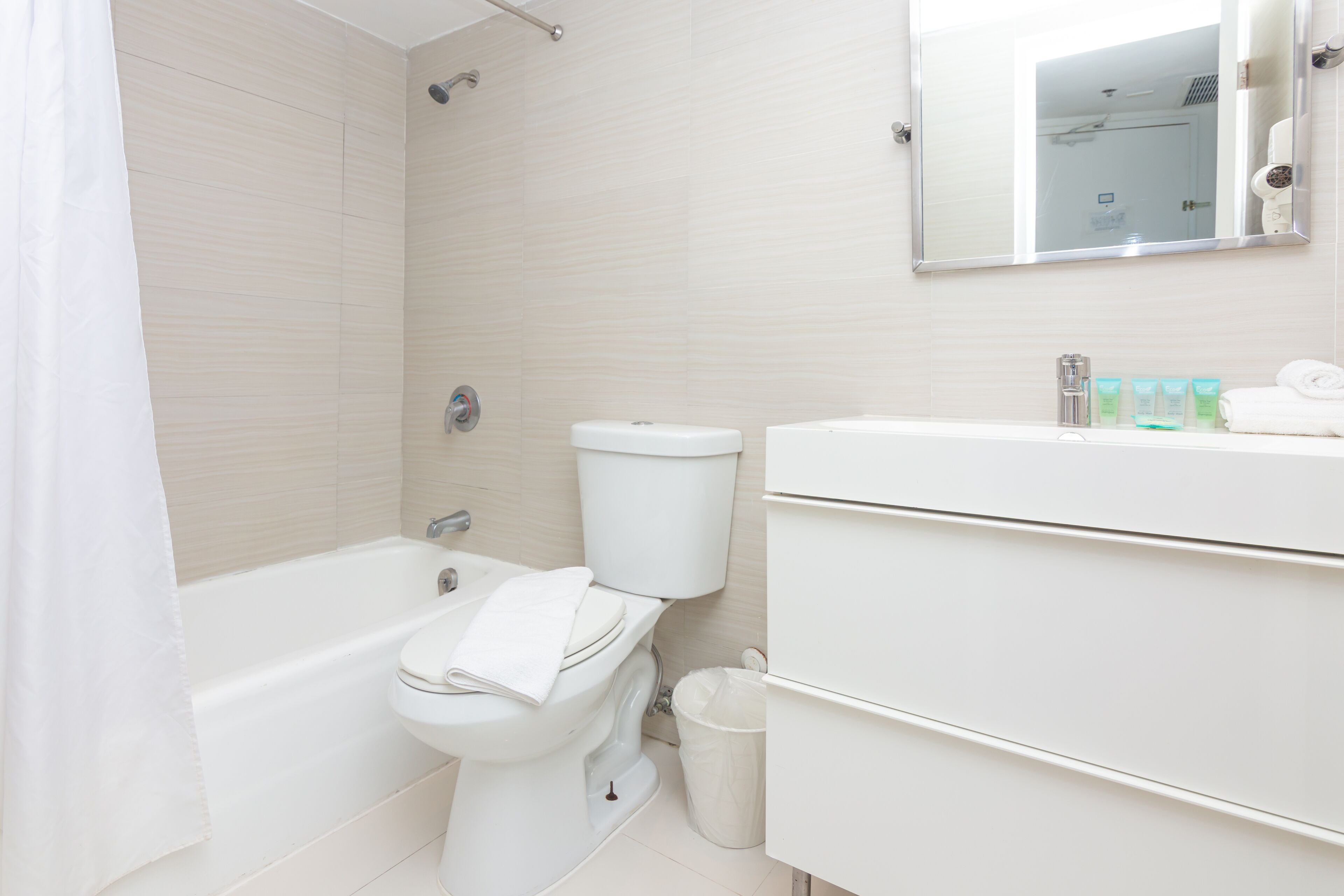 A modern bathroom with a bathtub, toilet, and sink.