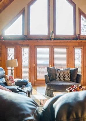 Una sala de estar acogedora con un ventanal grande, una chimenea y un espacio de estar confortable.