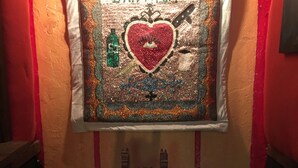 Un pequeño santuario con un adorno en forma de corazón, un candelabro y una caja de pañuelos.