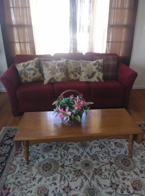 Relax in this inviting living room with a sofa, coffee table, and patterned rug.