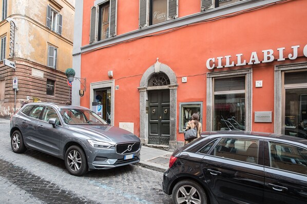 A street with parked cars and a building with a sign reading 'CILLABIJOX'.