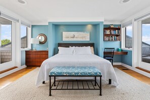 A bedroom with a bed, bedside table, lamp, and a bookshelf. - Lake Michigan beach home. Saugatuck. Heated pool, hot tub, 8 bedrooms. 9 baths.  (Saugatuck)