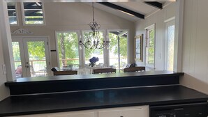 A kitchen with white cabinets, a black countertop, and a chandelier. - Old Lake Charm with Million Dollar Views (Troutman)