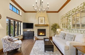 A living room with a fireplace, a television, and a sofa. - Romantic Private & Detatched Guest Home behind the gates of a Chateau on the Sea (Gig Harbor)