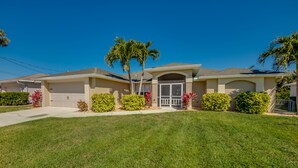 A single-story house with a garage, a front porch, and a well-maintained lawn. - 2621 SW 27th St. Cape Coral (Cape Coral)