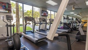 Une salle de sport équipée de tapis de course, d’elliptiques et d’un vélo d’appartement.