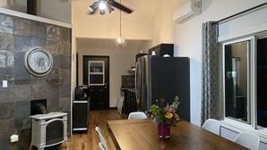 A modern kitchen with a wooden dining table, a built-in stove, and a refrigerator. - Fern Cottage Crystal Beach (Fort Erie)