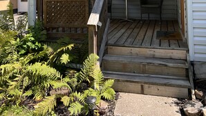 A wooden porch with a bench, a star decoration, and a welcome sign. - Fern Cottage Crystal Beach (Fort Erie)