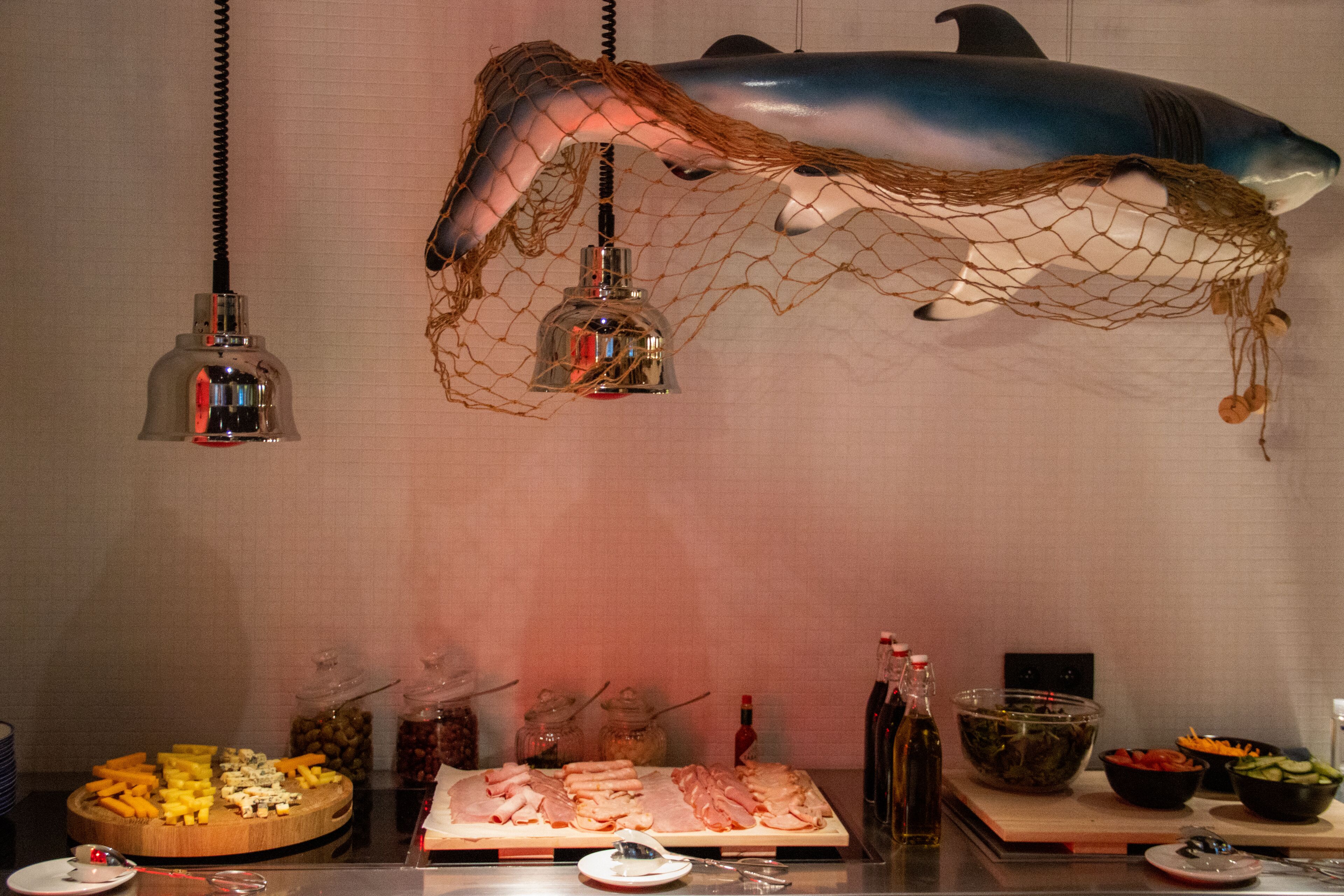 A buffet table with various food items and condiments.