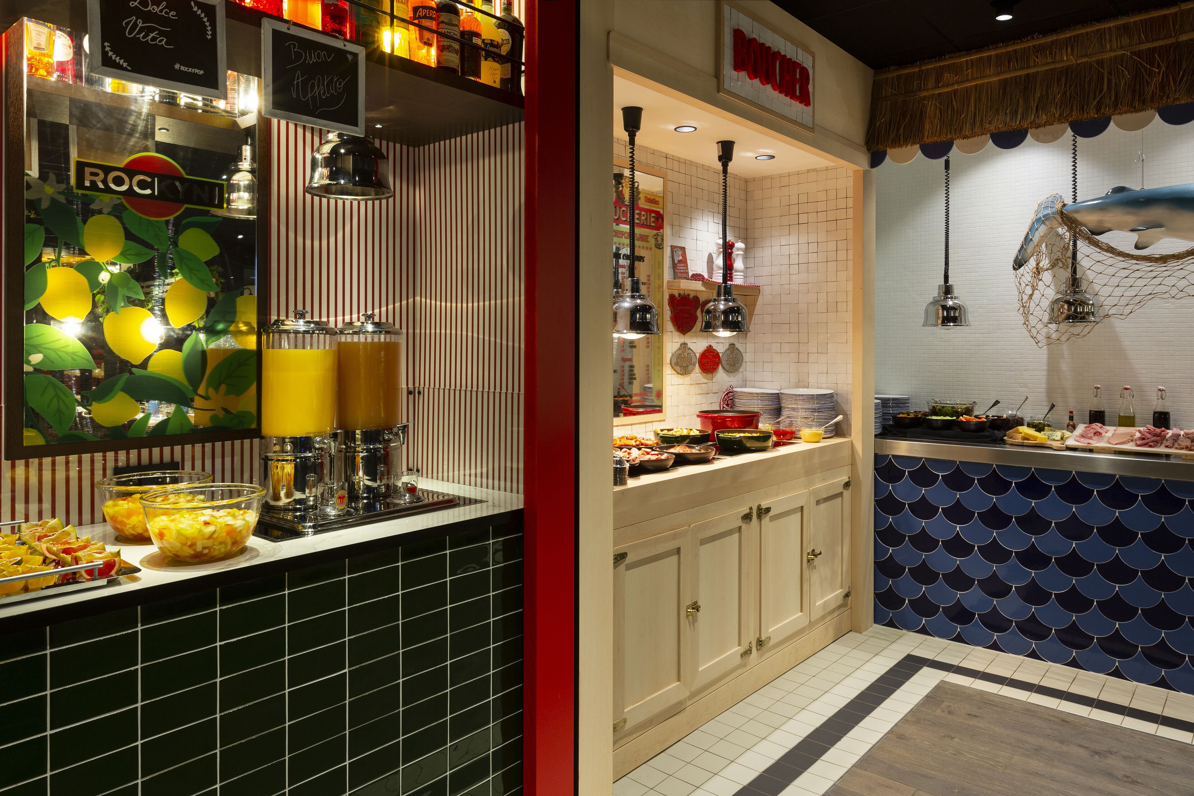 Un'area cucina con un'attrezzatura tipo buffet, che comprende una ciotola di frutta, un distributore di succo e diversi alimenti sul bancone.