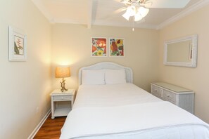 Un dormitorio con cama, mesita de noche, lámpara y decoración en la pared.