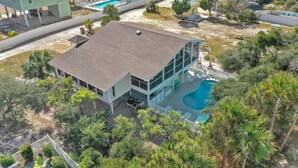 A large house with a swimming pool, surrounded by trees and other houses. - Cape Haus (Port St. Joe)