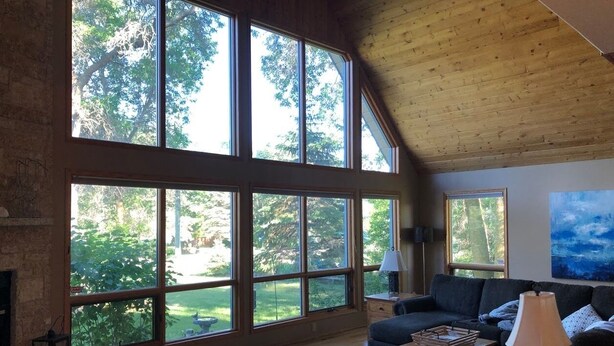 A spacious living room with large windows, a fireplace, a sofa, and a coffee table. - Lake Life meets Country Living Near Gimli (RM of Gimli)