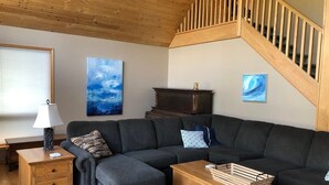 A modern living room with a sectional sofa, wooden coffee table, and a wooden nightstand. - Lake Life meets Country Living Near Gimli (RM of Gimli)