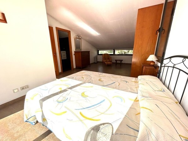 A bedroom with a bed, a chair, a small table, and a window. - Villa with a pool, parking, and Wi-Fi next to Roc de Sant Gaieta, with a view of the sea. (Roda de Berà)