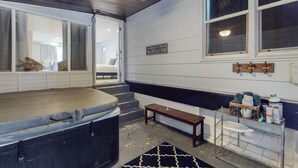 Une salle de spa équipée d’un bain à remous, d’un banc en bois et d’une fenêtre donnant sur un paysage agréable.