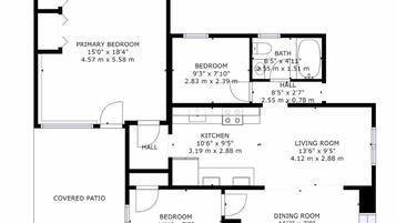 A floor plan of a house with a covered patio, primary bedroom, secondary bedroom, kitchen, living room, dining room, and a bathroom.