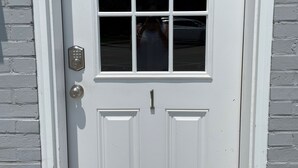 A white door with a window and a keypad lock. - Holland Suites, Suite #1 (Williamstown)