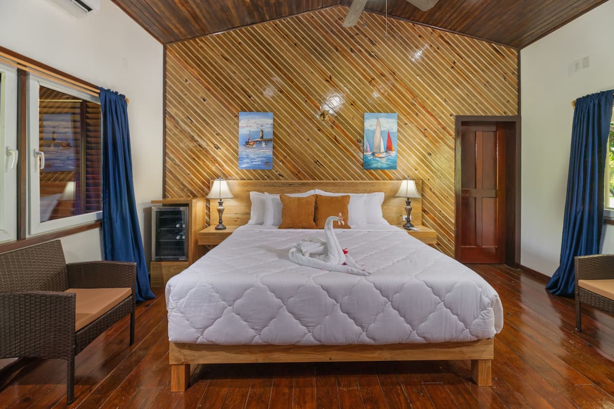 A large bed with a white quilt, two lamps, and a swan decoration.