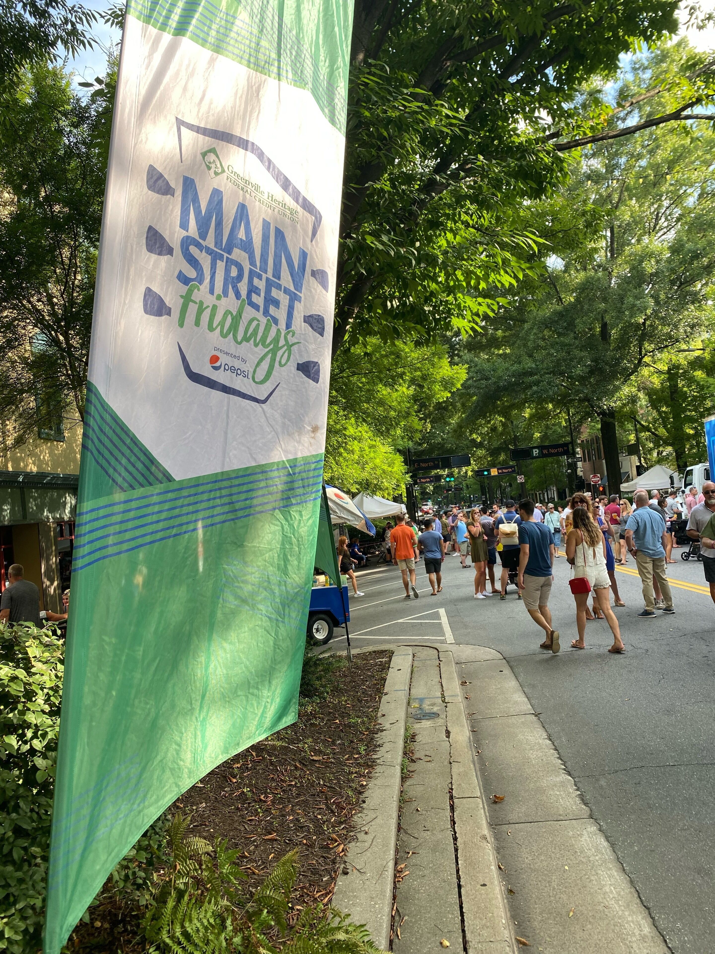 A street with a green banner advertising an event.