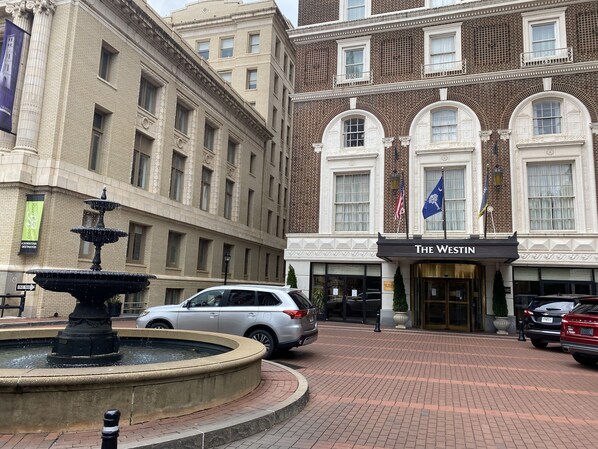 Un edificio con un letrero que dice 'The Westin' y una fuente al frente.